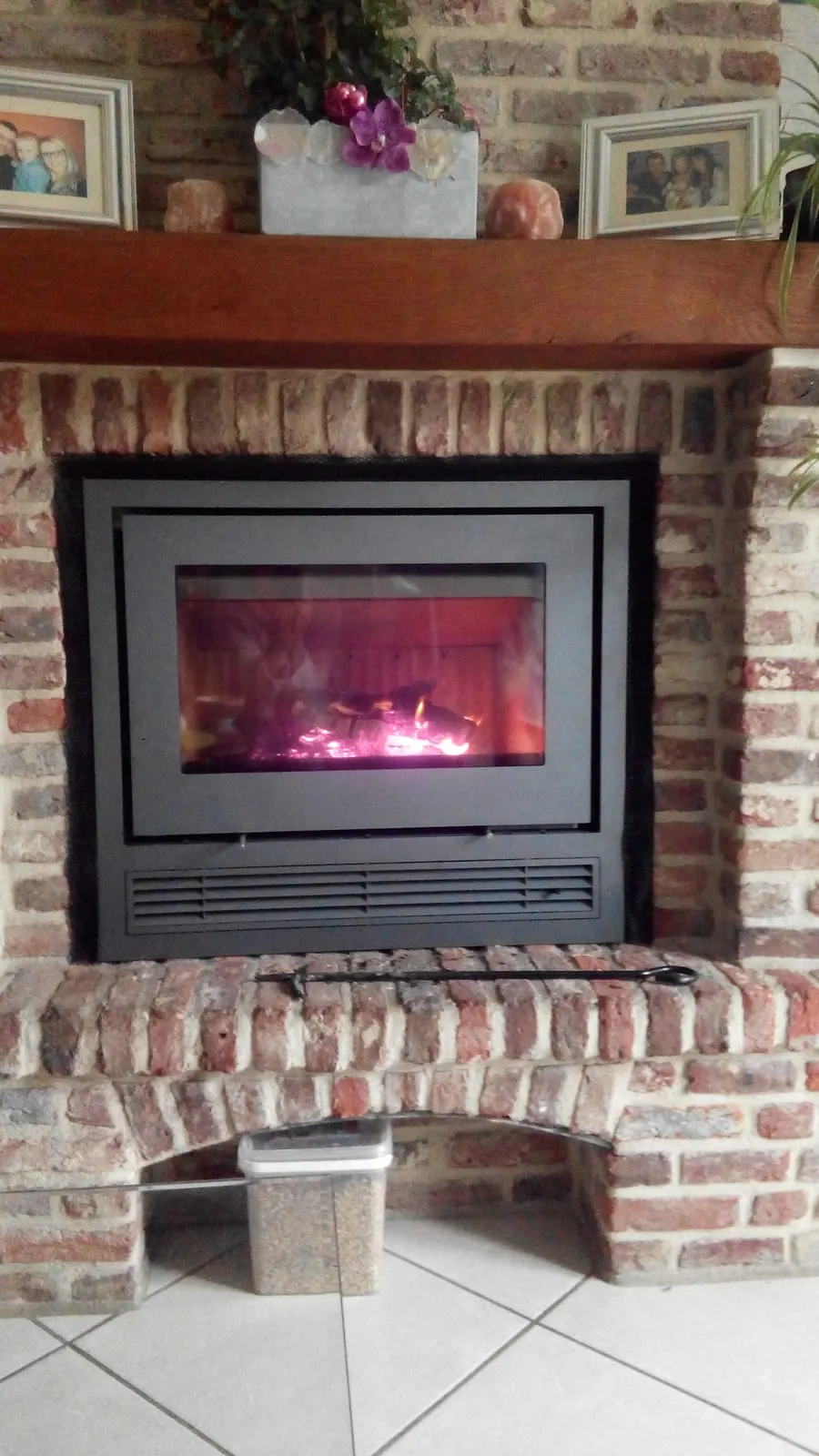 Insert à bois dans une cheminée en briques, installé par FK Énergie